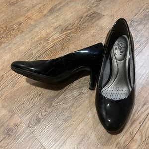 Women’s black pumps with a shiny finish.